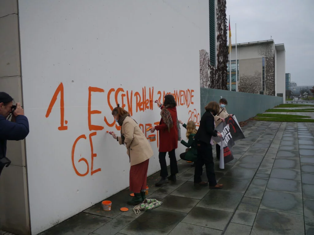 Activists from the last generation's uprising paint their demands to the Chancellery.