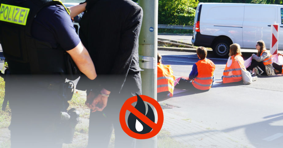 Einer Person werden von der Polizei Handschellen angelegt. Im Hintergrund sieht man eine Straßenblockade.