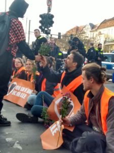 09.11.2022 - Passantin schenkt auf der Straße sitztenden Unterstützer:innen der Letzten Generation Blumen als zeichen der Unterstützung.